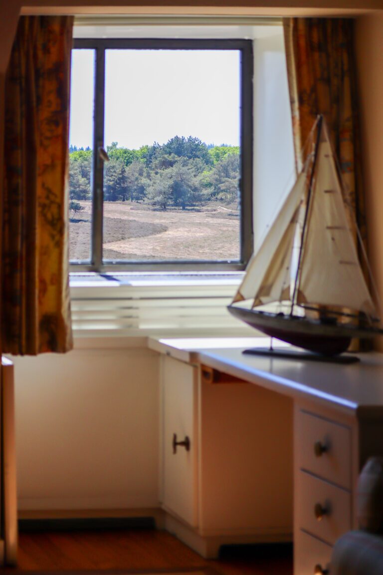 Een van de slaapkamers met een fraai uitzicht op de Noorderheide
