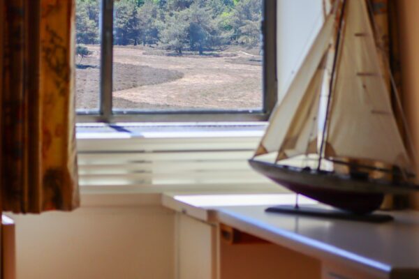 Een van de slaapkamers met een fraai uitzicht op de Noorderheide