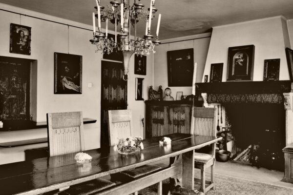 Een zwart-wit foto uit het verleden waarop een eetkamer te zien is