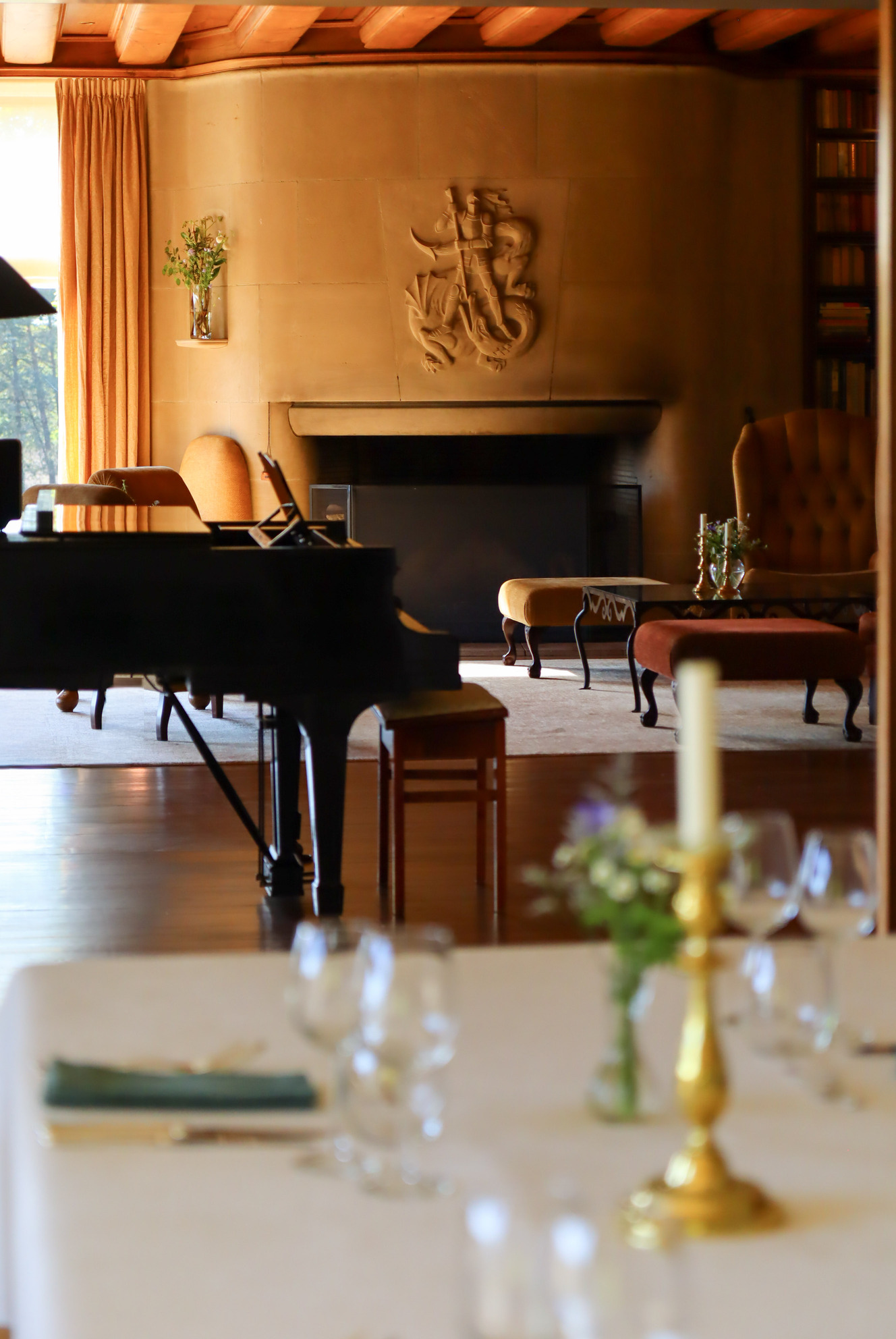 Een foto van de eetkamer van Landhuis Noorderheide met uitzicht op de haard en de piano in de zitkamer