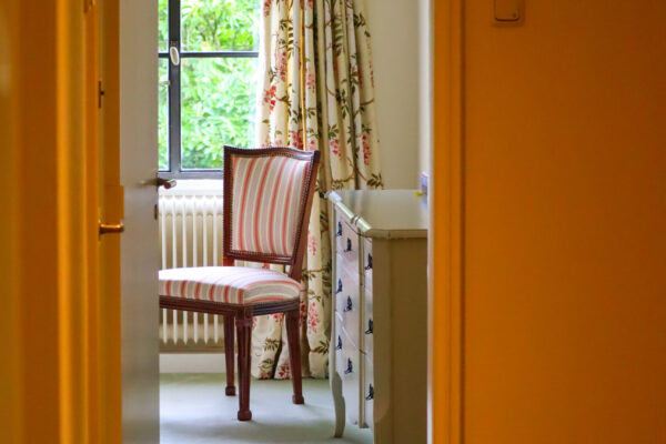 Een doorkijkje van de gang naar een van de slaapkamers die uitkijkt op de moestuin